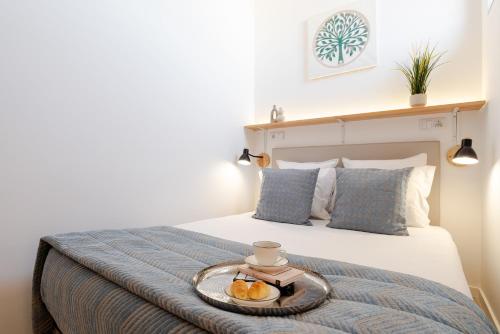 a bed with a tray with fruit on it at Authentic Studio with Terrace by HostWise in Porto