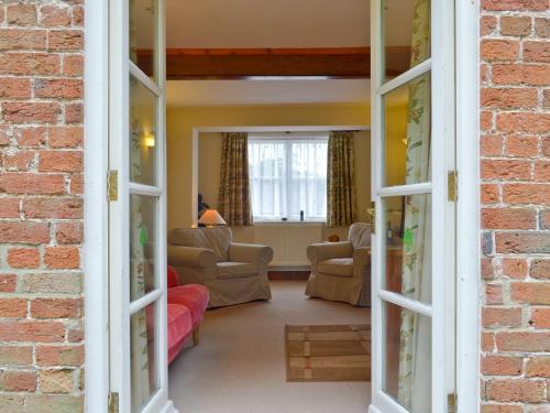 a view of a living room with a brick wall at Garden Farm Cottage in Ilam