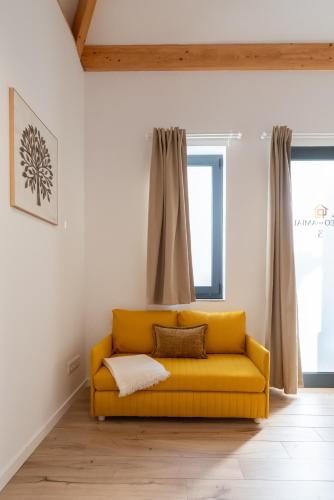 a yellow couch in a room with a window at Authentic Studio with Terrace by HostWise in Porto
