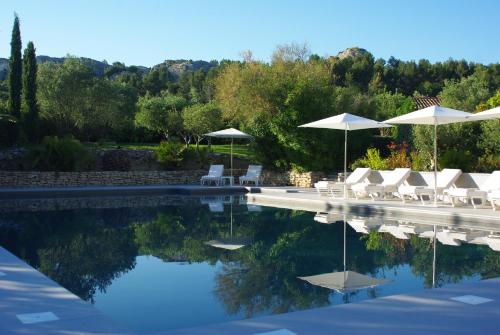 una piscina con sillas y sombrillas blancas en Bdesign & Spa en Paradou
