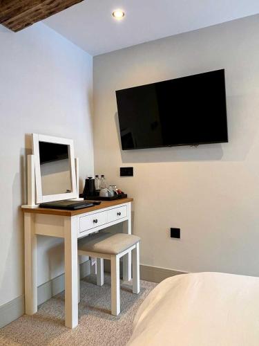 a bedroom with a desk with a computer and a tv at Cross Pipes Tavern and Rooms in Otley