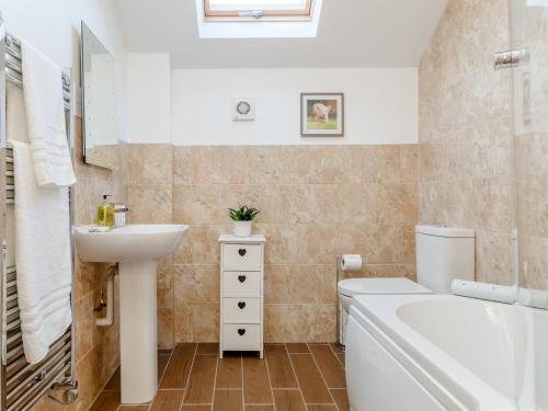 a bathroom with a sink and a toilet and a tub at The Old Laundry - Uk12136 in Hewelsfield