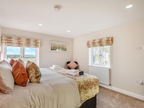 a bedroom with a bed and two windows at The Farm House in Elston