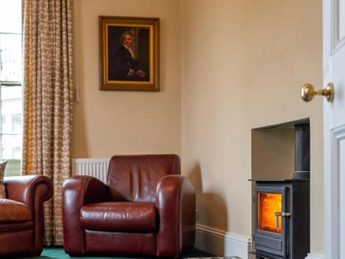 a living room with a chair and a fireplace at Langford Villa in Filey