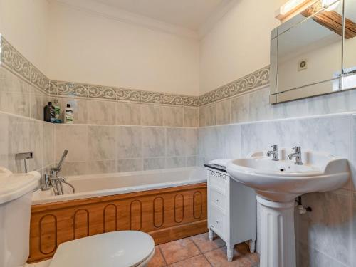 a bathroom with a sink and a tub and a toilet at The Stables - Uk30946 in Barthomley