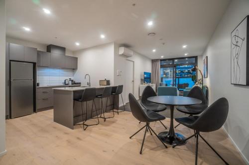 a kitchen with a table and chairs and a counter at High End Centrally located apartment with carpark in Auckland