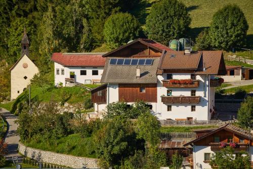 a house with solar panels on the roof and a church at Pfitscherhof in Campo di Trens