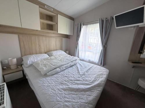 Postel nebo postele na pokoji v ubytování Lovely Caravan With Side Decking At Broadland Sands Park In Corton Ref 20160Bs