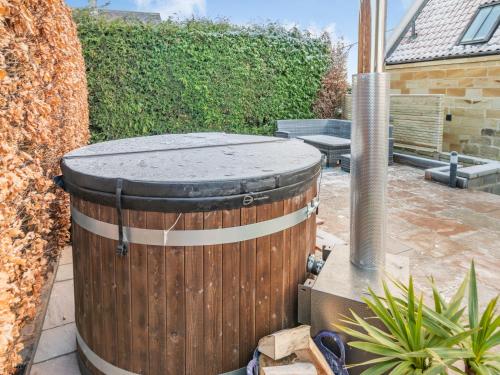 ein Holzfass auf einer Terrasse in der Unterkunft Forge Cottage in Liverton