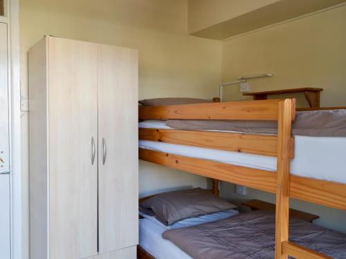 a bunk room with two bunk beds and a cabinet at Flat F1 in Dawlish Warren