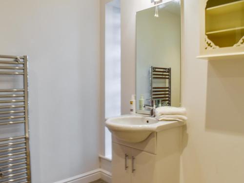 a white bathroom with a sink and a mirror at Swan House in Carnforth