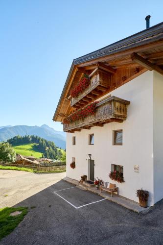 a white building with a balcony on the side of it at Pfitscherhof in Campo di Trens