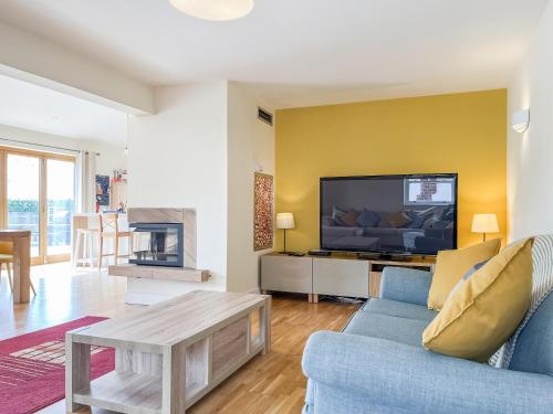 a living room with a blue couch and a tv at The Willows in Teversal