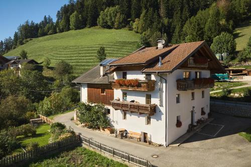 a white house with a balcony on a hill at Pfitscherhof in Campo di Trens