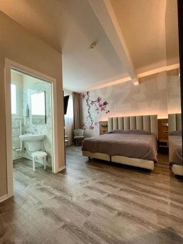 a bedroom with a bed and a sink and a bathroom at Hotel La Campagnola 1926 in Zevio
