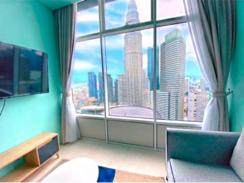 Una habitación con una gran ventana con vista a una ciudad. en Sky Suites KLCC By Elite Stay, en Kuala Lumpur