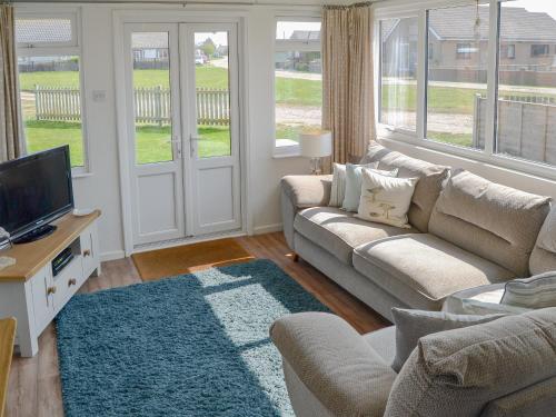 un soggiorno con un divano e una TV di Cottage By The Sea a Bacton