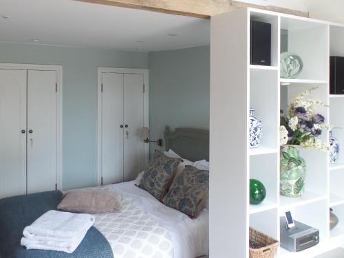 a bedroom with a bed with white shelves at The Cart Shed in Ibstone