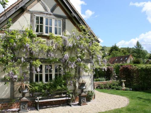 an old house with flowers on the side of it at The Cart Shed in Ibstone