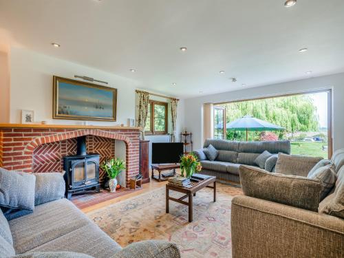 un salon avec des canapés et une cheminée dans l'établissement Riversdale Cottage, à Neatishead