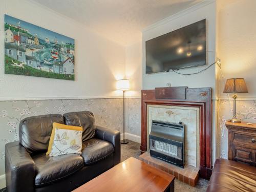 a living room with a couch and a fireplace at Trafalgar House in Gorleston-on-Sea