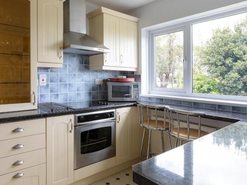 a kitchen with white cabinets and a stove top oven at Rockvale 1 in Salcombe