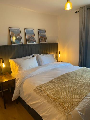 a bedroom with a large white bed with a wooden headboard at Charming cozy cottage in Guisborough in Guisborough