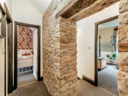 a room with a stone wall and a bedroom at Verona House in Tideswell
