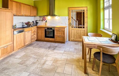 a kitchen with wooden cabinets and a table in it at Ferienhaus Hohen Demzin in Hohen Demzin