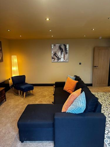 a living room with a blue couch and a chair at The Goodrington Sands- Apart Hotel in Paignton