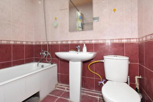 a bathroom with a toilet and a sink and a bath tub at Apartment in Glendel Hill in Yerevan