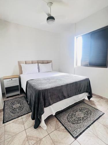 a bedroom with a bed with a table and a window at Apê Brisa do Mar in Pontal do Paraná
