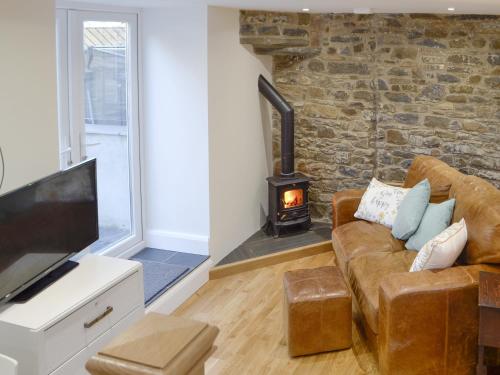 a living room with a couch and a fireplace at Cornel Clyd Cosy Corner in Cilcennin