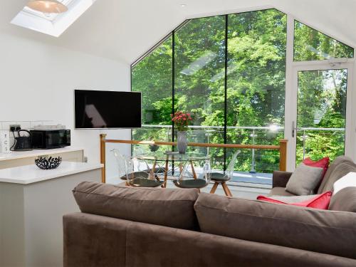 ein Wohnzimmer mit Sofa und großem Fenster in der Unterkunft Hidden Gem in Berrynarbor