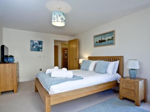 a bedroom with a bed with white sheets and blue pillows at Harbreck Heights -Masts B9 in Torquay