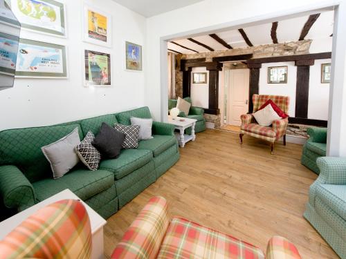 a living room with green couches and chairs at Crown Inn in Woolhope