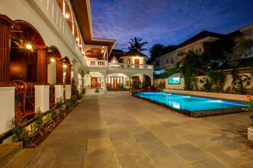 a house with a swimming pool in the yard at Villa Elixir Fort Kochi in Cochin