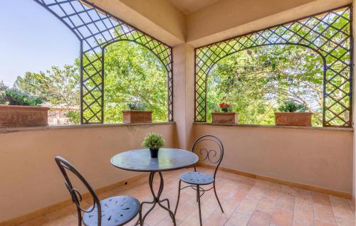 a table and chairs in a room with windows at Lovely Apartment In Montone With Wifi in Montone