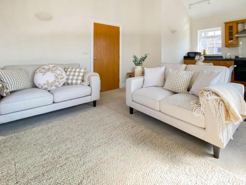 a living room with two white couches and a rug at The Guards Quarters - Uk47594 in Silloth
