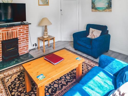 a living room with a couch and a table and a chair at Birch in Llanddona