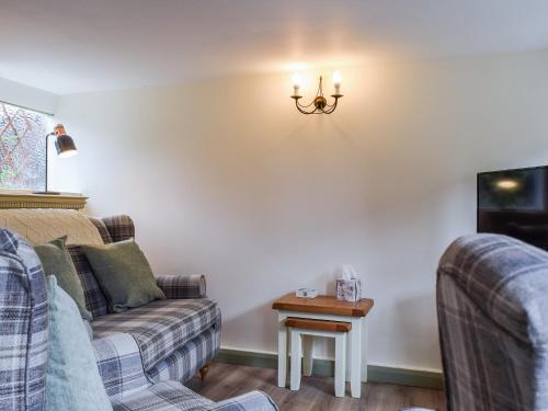 a living room with two couches and a table at Drapers Cottage in Foxton