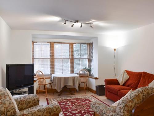 un salon avec un canapé et une table dans l'établissement Sycamore Cottage - Uk45923, à Ballater