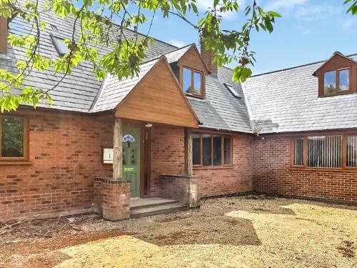 a home with a brick house with a green door at Grantham House in Grantham