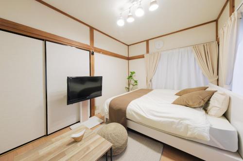 a small bedroom with a bed and a tv at Quiet 1K Full Room, Serta Queen Bed, Good to Shinjyuku & Ikebukuro, Belluna Dome, 201 in Tokorozawa