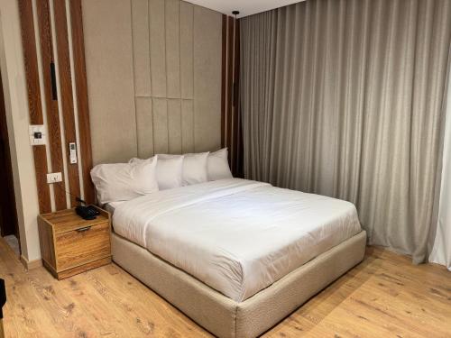 a bedroom with a white bed and a wooden floor at Palacio Pyramids Hotel in Cairo