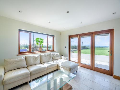 a living room with a white couch and windows at Sir A Wel in Llanerchymedd