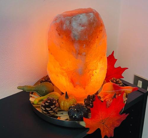 a large pumpkin sitting on a table with autumn leaves at MXP Relax House in Samarate