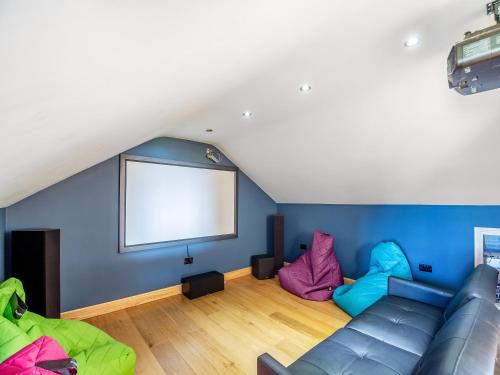 a living room with a couch and a blank screen at Sir A Wel in Llanerchymedd