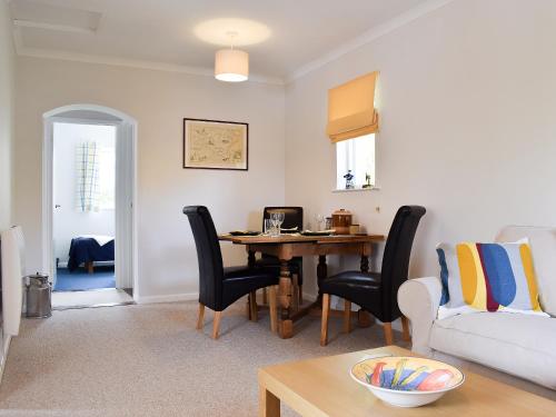 a living room with a table and a couch at Stonecot in Wootton Bridge