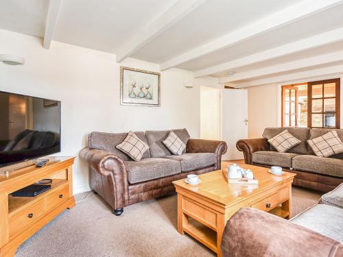a living room with two couches and a tv at The Farmhouse in St Austell